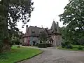 la Façade nord à pan-de-bois, et construction en brique et pierre du XXe&nbsp;siècle.