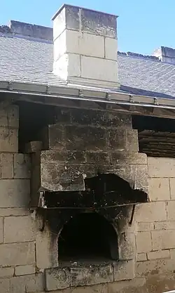 Photographie en couleurs d'un four inséré dans la partie extérieure du mur d'une maison.