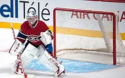 Photographie d'un gardien de but de hockey avec un maillot rouge