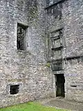 Entrée du château surplombée d'un panneau vierge encadré.