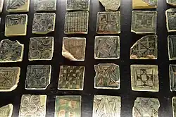 Photo de carreaux décorés de motifs géométriques dont des quadrillages, des rosaces et des cercles concentriques