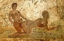 Un homme nu, à genoux, pénètre une femme nue à quatre pattes.