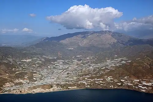 Vue générale, avec Castell de Ferro (es) (Gualchos) à gauche, la commune de Lújar au centre, le village de Lújar au pied de la sierra de Lújar (es) au fond, et une partie de Rubite à droite