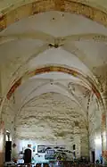 La nef vue depuis le chœur avec trois portes, à gauche, la porte méridionale de l'église, sur le mur du fond, la porte d'accès à la chapelle Sainte-Libérate, à droite la porte de la tour-escalier.