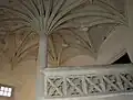 Escalier de pierre à colonne centrale et voûte en palmier.