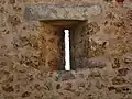 Archère à ébrasement simple et mur d'appui, château de la Madeleine.
