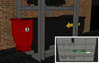 2. Le wagonnet plein ne parvient pas à chasser complètement le wagonnet vide, les deux arrêtoirs anti-recul (bloquant les essieux) se sont bien couchés lors de l'encagement mais l'arrêtoir "lolo" sur la roue avant droite a bloqué le second train de roues. Antonio Ianetta fait le tour de l'envoyage pour tenter de le débloquer.agrandir