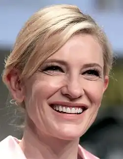 Photographie couleurs au format portrait d'une femme blonde au large sourire.