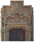 Porte à arc polylobé, lobe central en accolade et lobes latéraux en doucine.
