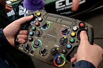 Bouton KERS blanc sur le côté gauche du volant d'une Caterham F1 de 2012.