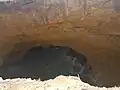 Cavité naturelle en pleine terre formée par un effondrement de la voute.
