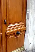 Un bouton de porte ornemental au centre d'une porte cochère à Paris.