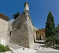 Route d'accès principale à l'enceinte du château, mélangeant des éléments du XVIIe&nbsp;siècle (remparts, échauguette) et médiévaux (Porche d'entrée, mur, blason) (2014)
