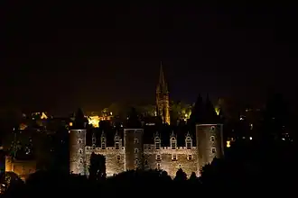 Vue nocturne du château et de la basilique Notre-Dame-du-Roncier en arrière-plan.