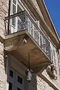 le balcon du premier étage soutenu par des voussoirs.