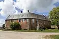 Château-ferme de Chocqueuse, logis reprenant la forme de l'ancien chemin de ronde de la forteresse médiévale, vue depuis le sud-est.