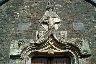 Accolade sur le portail de la chapelle de Millières (Manche), fin XVe-début XVIe siècle.