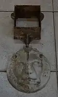 Cache-boulin articulé en fonte. La partie cubique était insérée dans le trou de boulin (Charleroi, seconde moitié du XIXe&nbsp;siècle).