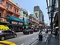Charoen Krung Road "New Road" et ses "compartiments chinois" (shophouses) avec en arrière-plan Sathorn Unique