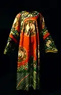 Qipao semiformelle à manches longues. Dynastie Qing XIXe&nbsp;siècle. Broderie de soie et fils de métal "enveloppés". Dallas Museum of Art.