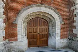 Le porche en plein cintre portant la date de 1645 ..