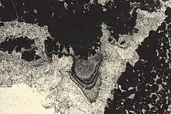 Ciment stalactite au toit d'un « keystone vug » typique de la diagenèse en milieu vadose, au sommet d'un cycle émersif L = 0,3&nbsp;mm.