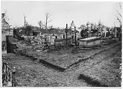 Le cimetière avec tombes allemandes, et, au loin, ruines du village (mars 1917).