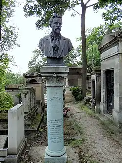La colonne de la tombe de la famille Robinet. Le chapiteau est du style art-déco, et surplombé par un petit bonnet phrygien. En haut de colonne, un buste de François-Roland Rolard, vêtu d'un costume. Il possède une cravate en lavallière, une moustache et une petite barbe sur le menton ainsi que des cheveux courts. Six noms sont inscrits sur la colonne, trois sont illisibles. Les autres sont : « Gabriel Robinet, 15 mars 1849 - 26 juillet 1887. Docteur Robinet, exécuteur testamentaire d'Auguste Comte, historien de Danton, 24 avril 1825 - 2 novembre 1899. L. Gabriel-Robinet, membre de l'Institut, 1909 - 1975. » La devise positiviste est aussi gravée sur la colonne : « L'amour pour principe, l'ordre pour base et le progrès pour but » ; sur son socle il est écrit « Concession à perpétuité. »
