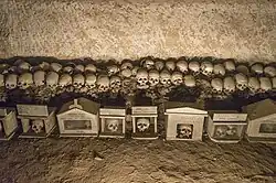 Crânes anonymes et leurs boîtes dévotionnelles portant des ex voto dans la nécropole des Fontanelle, à Naples.