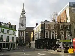 Église centrale, enserrée de bâtiments s'ouvrant en V.