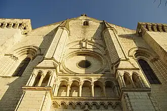 Photographie en couleurs et en contre-plongée de la façade d'une église avec un oculus en son centre.
