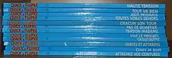 Photo en couleur d'une pile d'albums dont on voit les reliures bleues