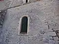 Des pierres sont  disposées en arête-de-poisson au-dessus de l'arcade murée.