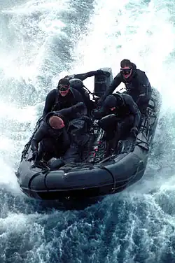 Des SEAL de la Team Five en exercice à bord d'un canot pneumatique — Combat Rubber Raiding Craft&nbsp;(en) — en 2000.