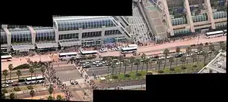 Composition de photographies en couleur montrant une foule de badauds et véhicules devant un bâtiment vitré.