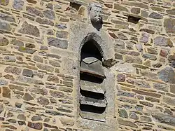 Corbeau à tête grotesque sur fenêtre en arc bouté face est.