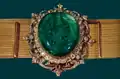 La ceinture du couronnement : cette ceinture a été tissée en fils d'or, elle mesure 119 cm de long. L'émeraude formant une partie de la boucle pèse 175 carats et est entourée de nombreux petits diamants. L'histoire de cette ceinture n'est pas connue, hormis le fait qu'elle remonterait au moins au XVIIe&nbsp;siècle. Les deux chahs Pahlavi l'ont portée pour leur couronnement.
