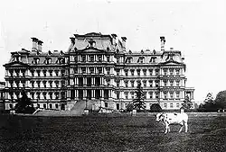 Vue de l'immeuble au début du XXe&nbsp;siècle. La vache au premier plan est Pauline, la dernière vache à avoir vécu à la Maison-Blanche et qui fournissait le lait pour le président Taft (1909-13).