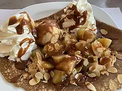 Avec crêpe, fruits et crème glacée.
