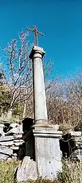 Photographie du socle et d'une croix édifiée en béton blanc.