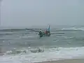 Départ d'un bateau pour poser le xalavar en mer. Les grands avirons sont utilisés avant que le moteur hors bord en puits puisse prendre le relais.