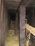 Détail de l’intérieur de la galerie lors de sa découverte en 2010 avec un lit constitué d’un sommier en bois associé à du grillage métallique.
