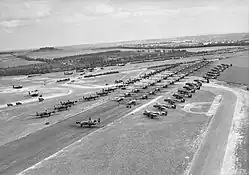 Photo aérienne en noir et blanc d'un grand nombre d'avions de combat sur une piste de base aérienne.