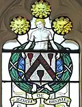 Armes de De Brome par Ninian Comper. Notez l'éphèbe nu tenant le blason.