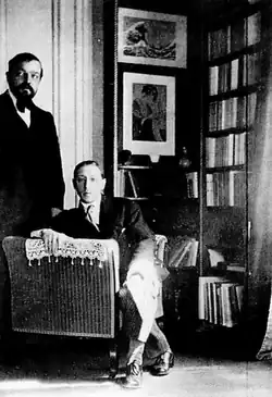 Photographie en noir et blanc montrant Debussy debout et Stravinsky assis.
