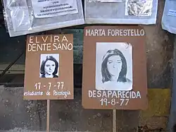 2 Pancartes fichées au bout d'un bâton où apparaissent les portraits noirs et blancs de deux jeunes filles qualifiées de disparues.