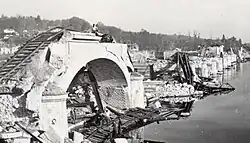 Photographie en noir et blanc d'un pont détruit.