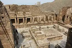 Takht-i-Bahi. Cour des stupa votifs. Mur à d. : cellules consacrées aux statues de grande taille. Centre : plateformes d'un grand et de petits stupa, IIe&nbsp;siècle