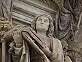 Vue de la tête de la sculpture avec son livre au premier plan.