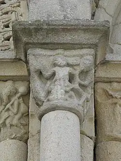 Photo d'un chapiteau en granite, avec une femme dont les seins sont dévorés par un crapaud.